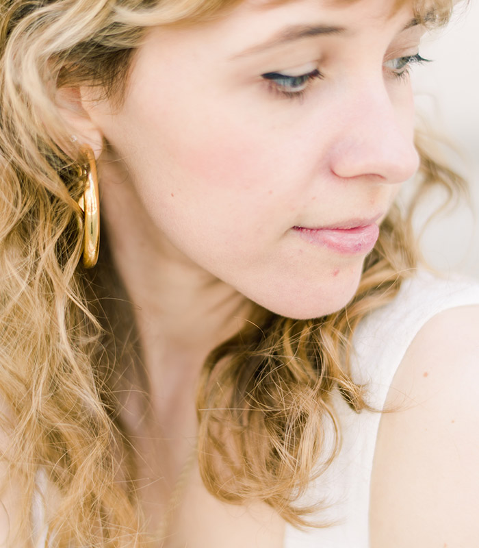 Woman touching her ear while noticing ringing from tinnitus